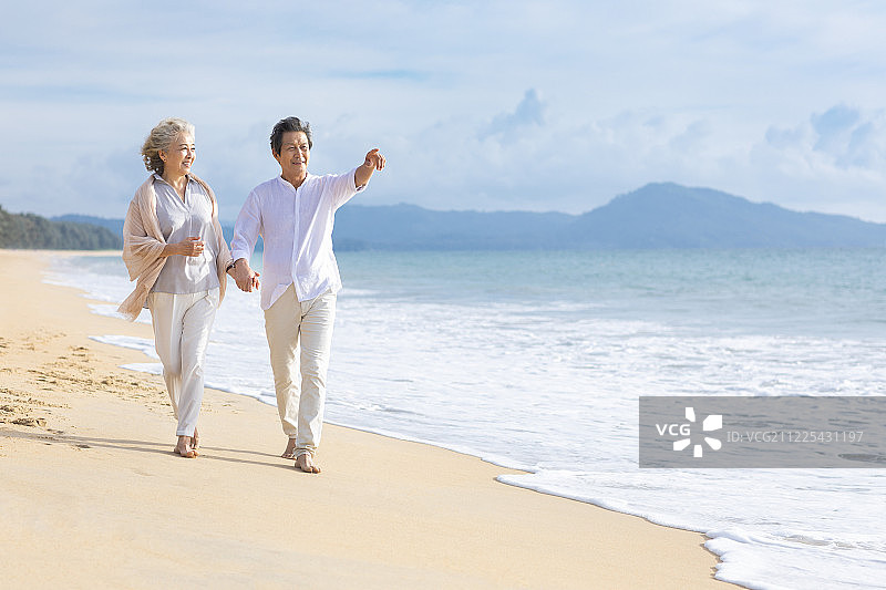 快乐的老年夫妇在沙滩散步图片素材