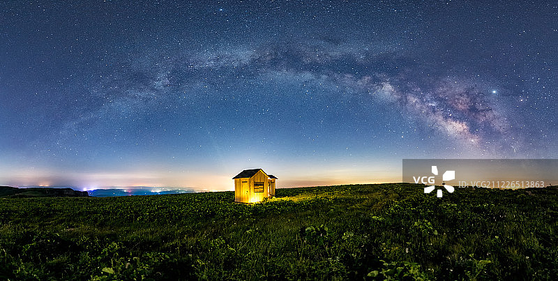 夜晚银河拱桥下的高山草甸小木屋户外风光图片素材