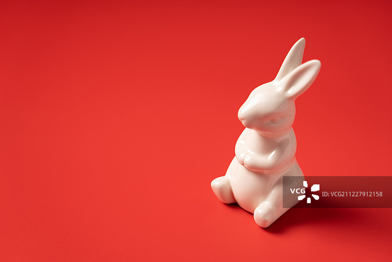 红色背景中的白色兔子图片素材