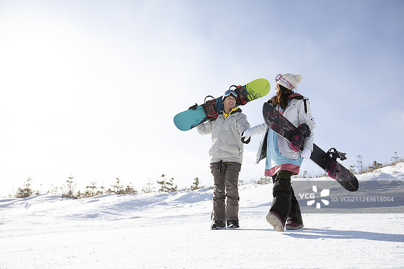 快乐的年轻情侣在雪地上行走图片素材