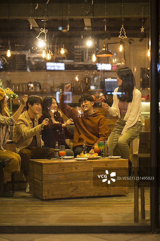 五个青年男女一起在酒吧聚会嬉戏放烟花欢度圣诞节图片素材