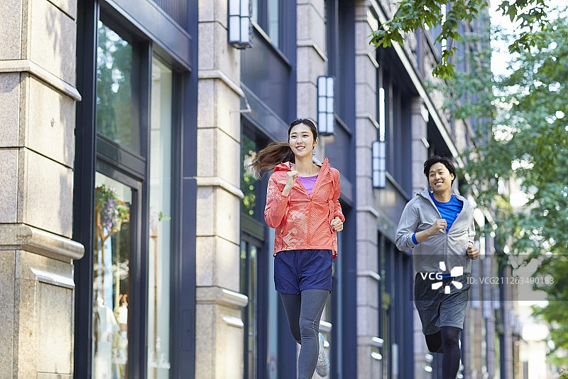 一对年轻的日本夫妇在东京市中心跑步图片素材