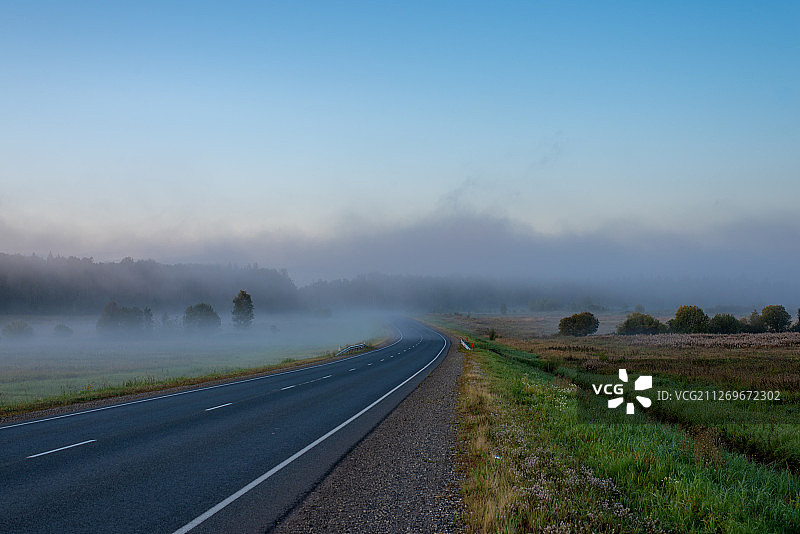 雾蒙蒙的日出掠过公路图片素材