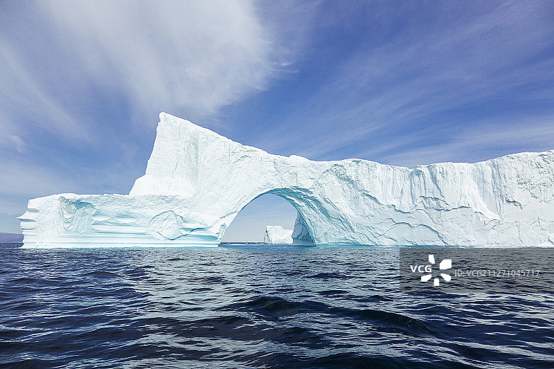 雄伟的冰山拱门在阳光明媚的蓝色大西洋格陵兰岛图片素材