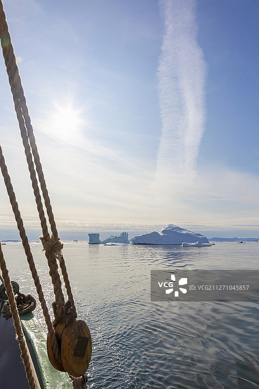 从阳光明媚的大西洋格陵兰岛上的帆船上看到的冰山图片素材