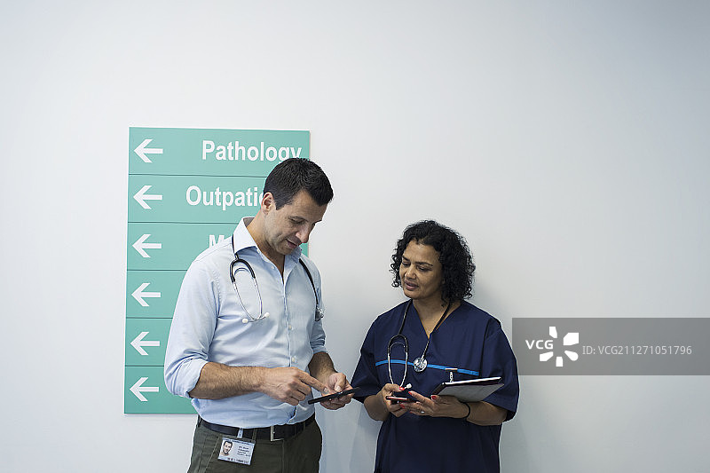 医生在医院走廊里用智能手机通话图片素材