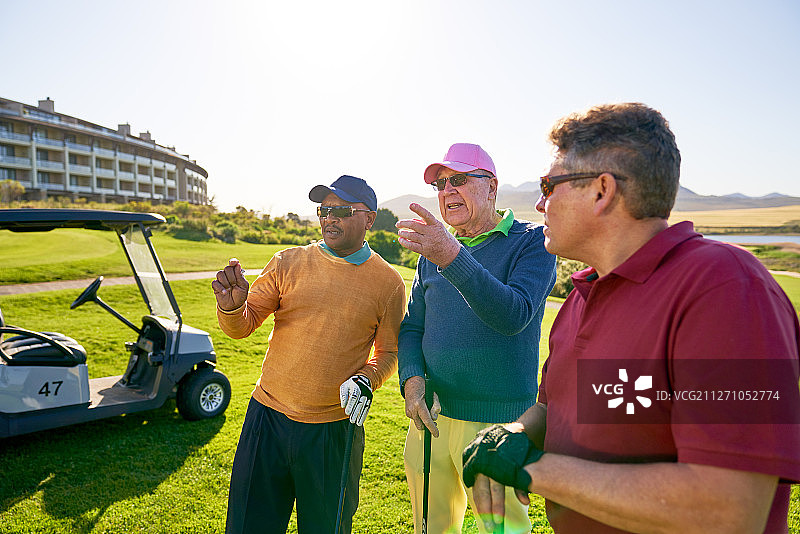 男高尔夫球手朋友在阳光明媚的高尔夫球场上交谈图片素材