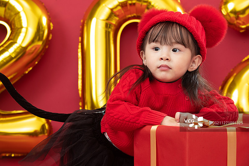 可爱的小女孩趴在新年礼物上图片素材