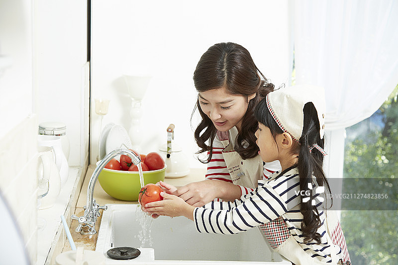 母亲和女儿在厨房洗西红柿的照片图片素材