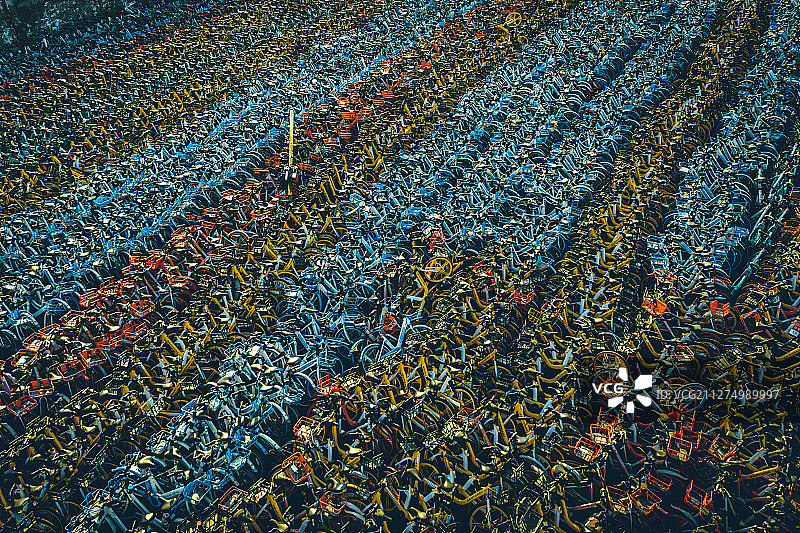 大量排列紧密整齐的荒废的多种颜色共享单车停车场图片素材