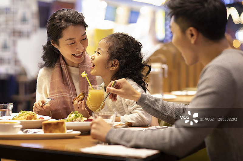 快乐的年轻家庭在餐厅就餐图片素材