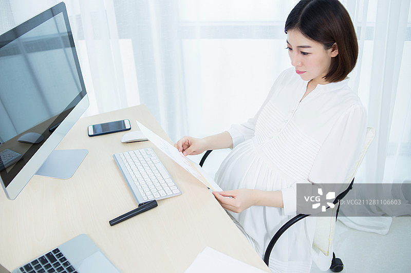 怀孕的女人正在办公室办公图片素材