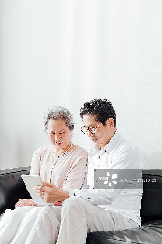 亚洲老年夫妇使用平板电脑图片素材