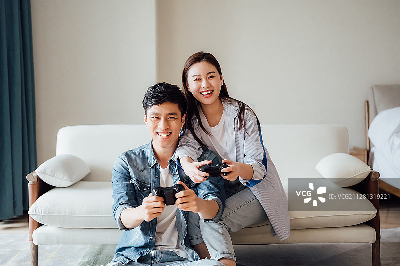 亚洲年轻情侣在家打游戏图片素材