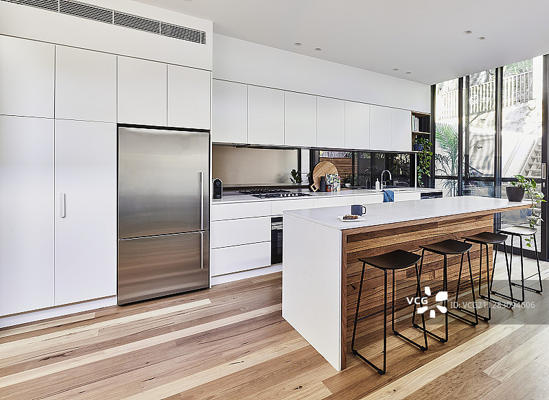 大型现代厨房，木地板，岛台和玻璃墙图片素材