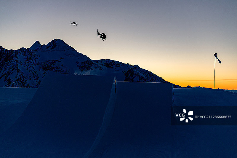 清晨，一名滑雪者和一架无人机在奥地利山区进行世界杯训练图片素材