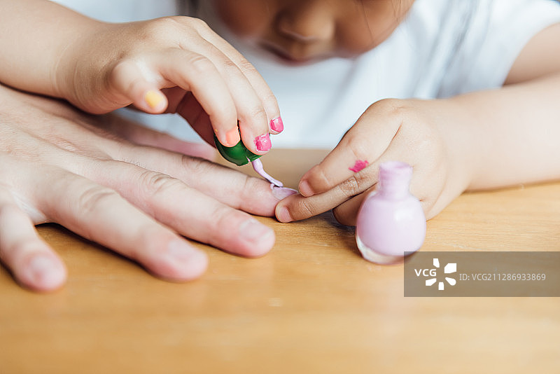 亚洲父亲和女儿正在涂指甲油图片素材