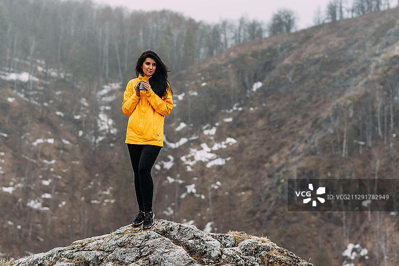 穿着运动服的女人站在一块岩石上，俄罗斯的马拉科沃图片素材