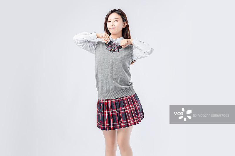 纯色背景里,身穿校服的亚洲女孩图片素材