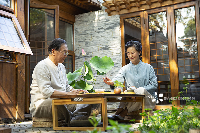 老年夫妻在户外庭院喝茶下围棋图片素材