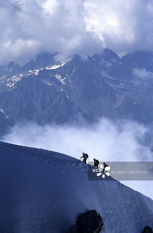 三名登山运动员攀登法国阿尔卑斯山，背景是夏蒙尼图片素材
