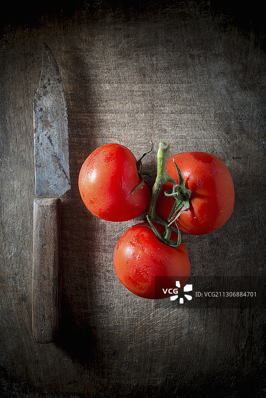 藤蔓成熟的西红柿在一个木制的背景图片素材