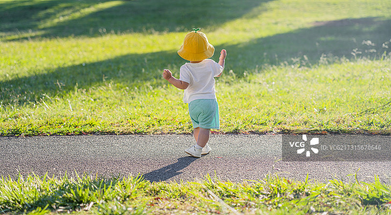 野外草坪小道上跑步的男婴图片素材