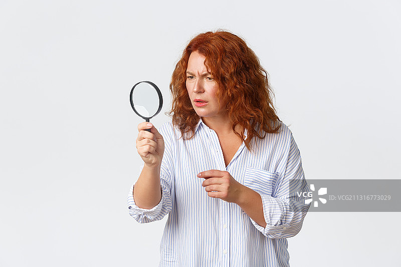 手持放大镜的女子肖像，背景为白色图片素材