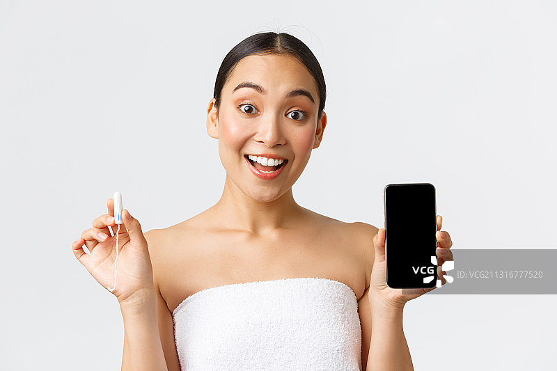 在白色背景下，微笑的年轻女子手持手机的肖像图片素材