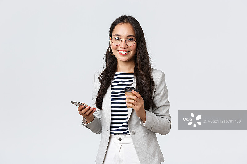 微笑的女商人拿着平板电脑，站在白色的背景下图片素材