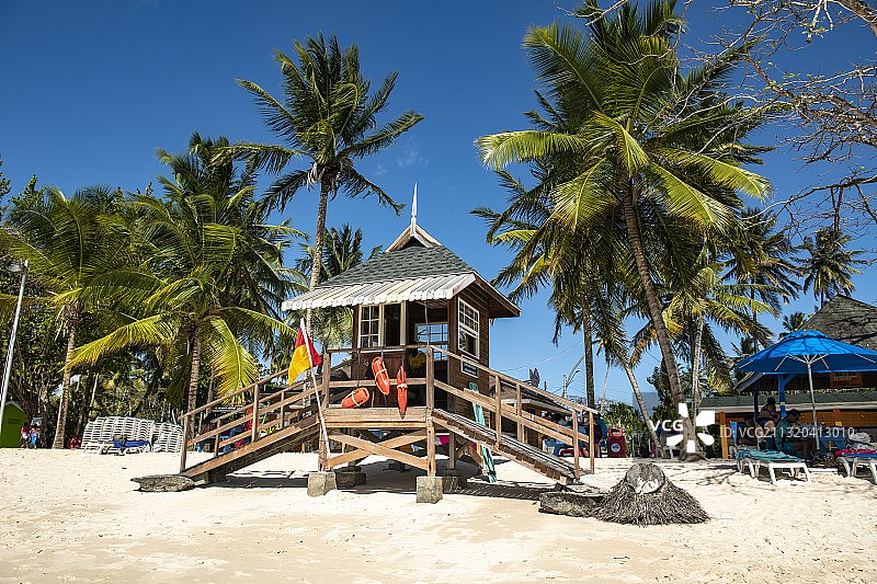 一个风景如画的救生员站在海滩棕榈树之间，鸽子点，多巴哥，特立尼达和多巴哥，加勒比图片素材