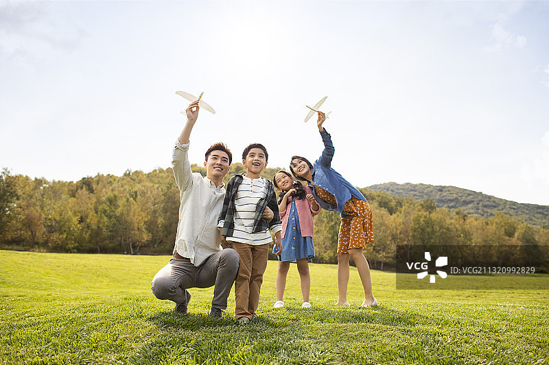 快乐的的年轻家庭在草地上玩耍图片素材