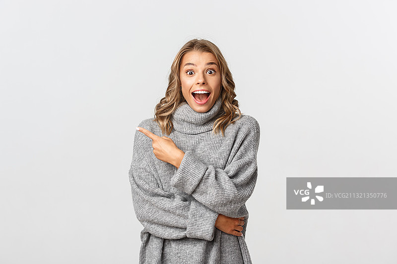 肖像快乐的年轻女子穿着毛衣的灰色背景图片素材
