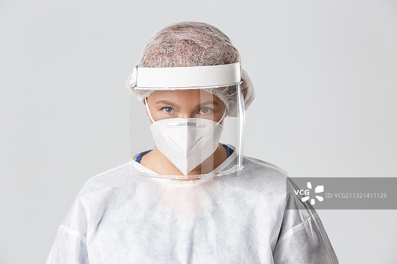 灰色背景下男孩戴着外科口罩的肖像图片素材
