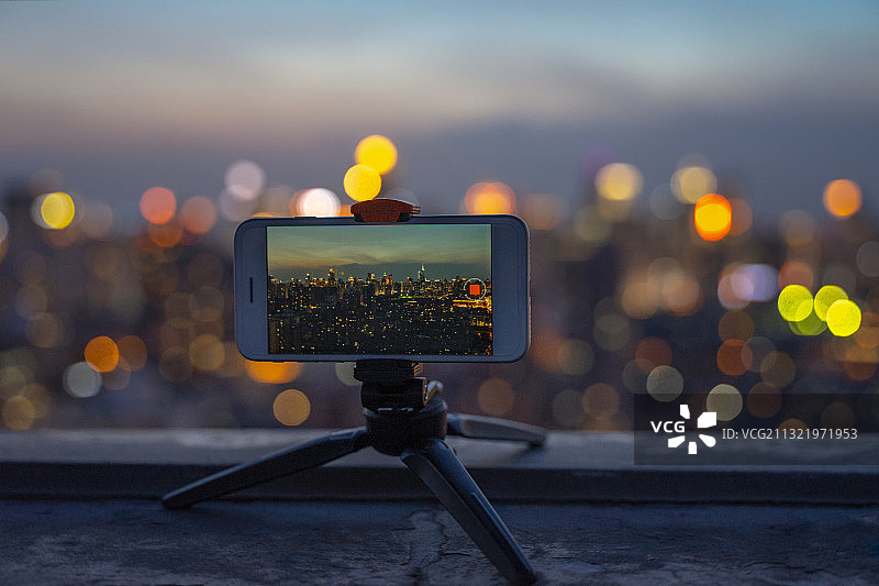 正在拍摄城市夜景的智能手机图片素材
