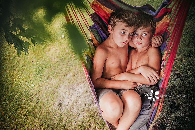 美国伊利诺斯州莱娜市，一对赤膊的双胞胎兄弟躺在吊床上图片素材