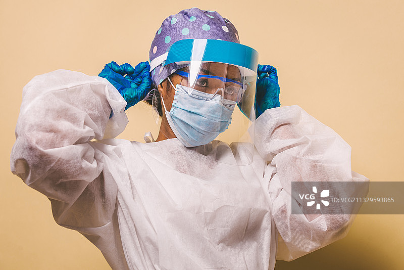 女医生戴着外科口罩，背景是彩色的图片素材