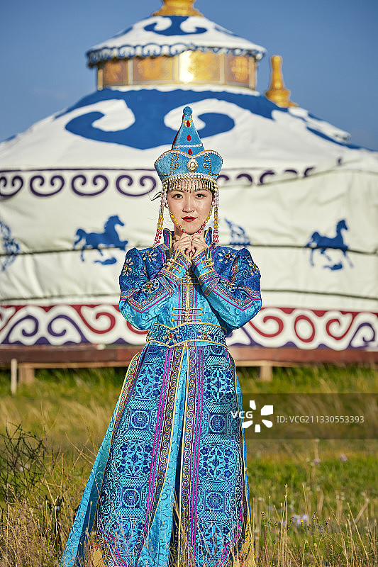 草原上蒙古包前穿着蒙古族传统服饰的少女图片素材