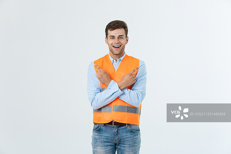 微笑的工程师的肖像与双臂交叉站在白色的背景图片素材