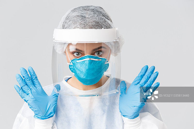 女医生戴着外科口罩的肖像，以白色为背景图片素材
