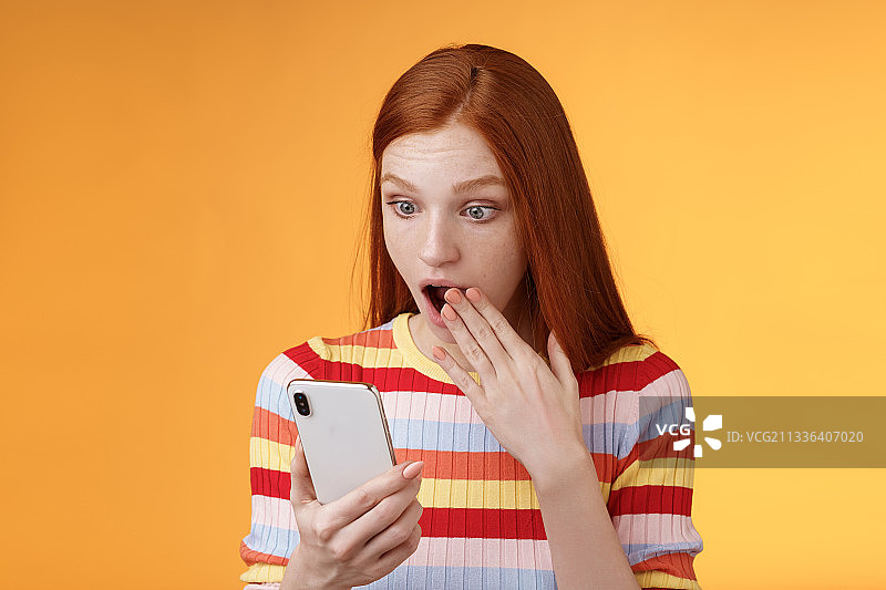 年轻女子的肖像使用手机的橙色背景图片素材