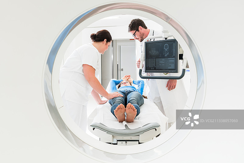 医生、护士和病人在医院进行CT断层扫描时，被射穿了导管装置图片素材