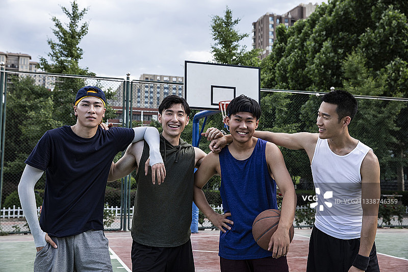 四个青年男子在学校篮球场打篮球比赛肖像图片素材