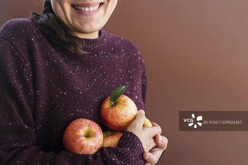 快乐的女园丁抱着新鲜的苹果图片素材