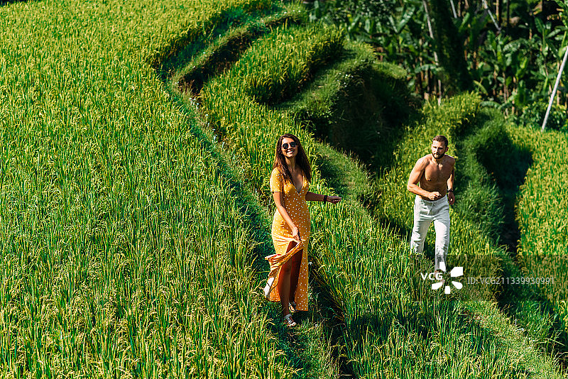一对夫妇在田里的植物中散步图片素材