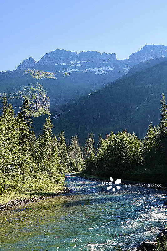 美国蒙大拿州冰川国家公园，树木与天空相衬的河流风景图片素材