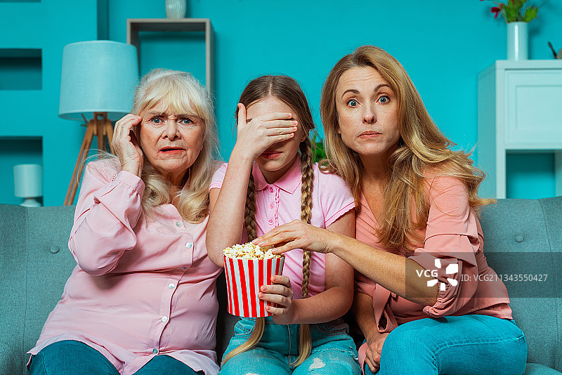 奶奶、女儿和孙女一起在家里看恐怖电影图片素材