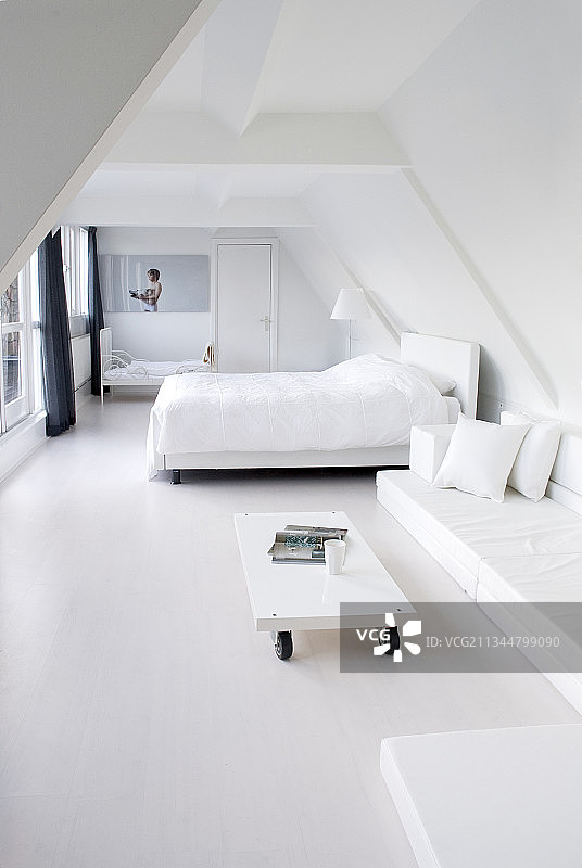 极简主义，白色卧室下面倾斜的天花板图片素材