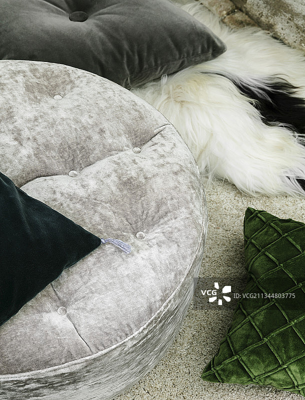 灰色和绿色的天鹅绒坐垫上有毛皮毯子和地毯图片素材