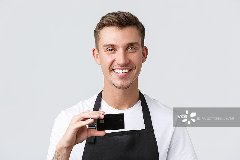 白色背景下，微笑的商人拿着信用卡的肖像图片素材